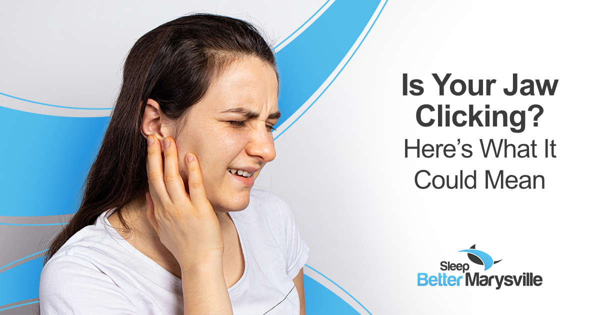 Woman touching her jaw because of pain or clicking sensations that may be related to TMJ disorder