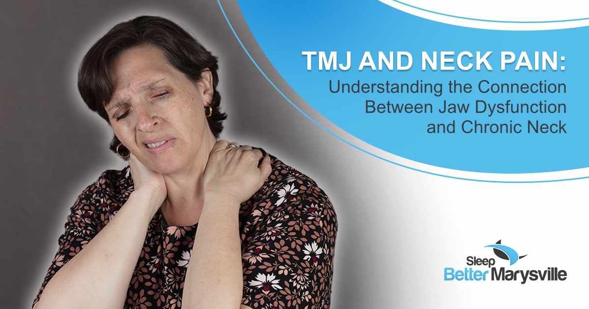 Woman holding her neck while experiencing pain that may be related to TMJ disorder